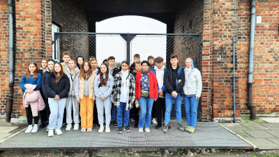 Uczniowie na tle budynku z czerwonej cegły w w Auschwitz-Birkenau