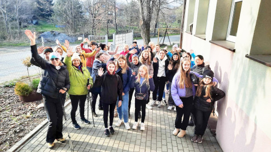 Uczestniczki marszu kobiet stoją przed budynkiem szkoły i pozują do wspólnego zdjęćia.